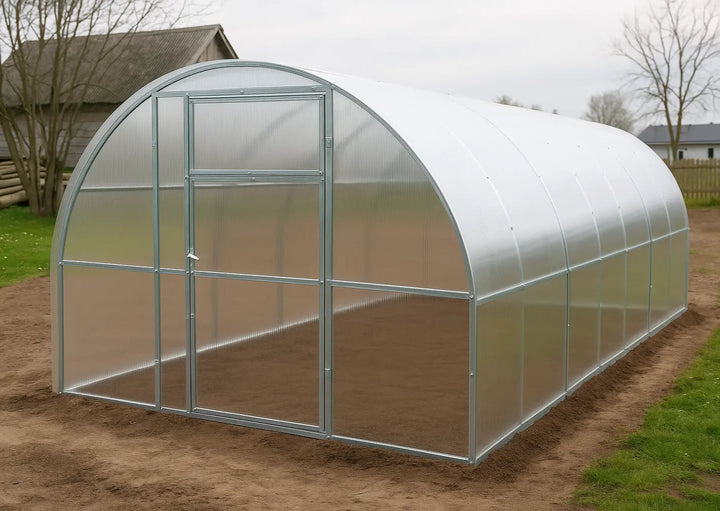 Polycarbonat greenhouse Titan plus  width 3,5m on a grass patch with trees and houses in the background